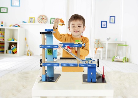 bambino che gioca con garage di legno